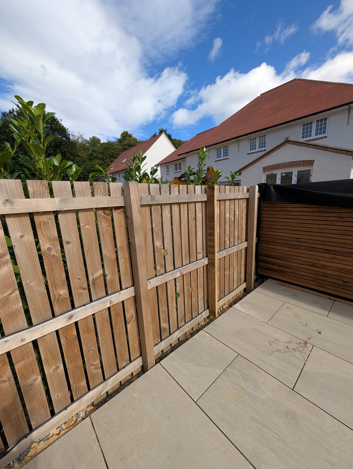 Paved garden area beside timber screening